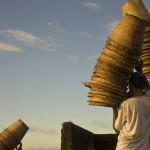 Worker carries acai baskets at Macapa city harbor, Brazil.